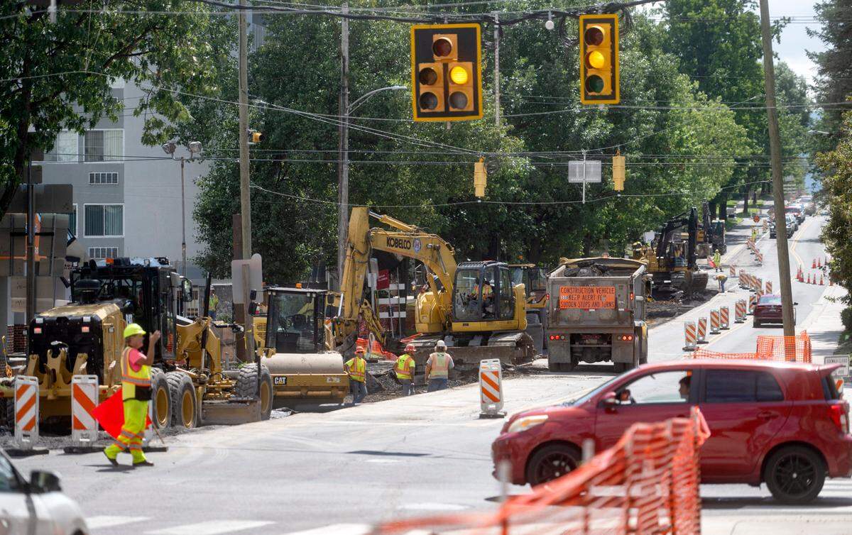 A flagger controls traffic at the intersection of Atherton Street and Beaver Avenue on Thursday, Aug. 17, 2023.