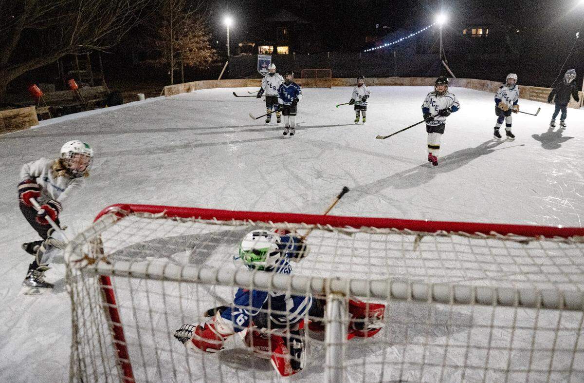 Friends enjoy the ice rink in Bill Dickson’s backyard in Lemont on Thursday, Feb. 20, 2025.