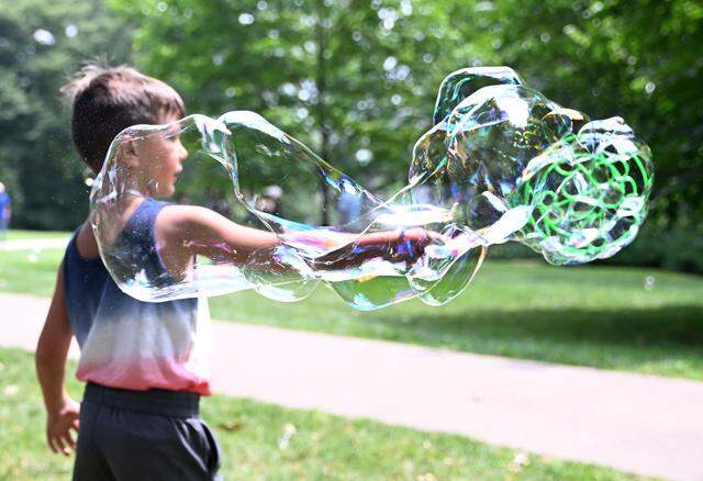 Matthias Mapston, 7, of Shenandoah Valley, Virginia, creates giant bubbles during Wednesday’s Children and Youth Day at the 57th Central Pennsylvania Festival of the Arts in State College. (Steve Manuel/for the CDT)