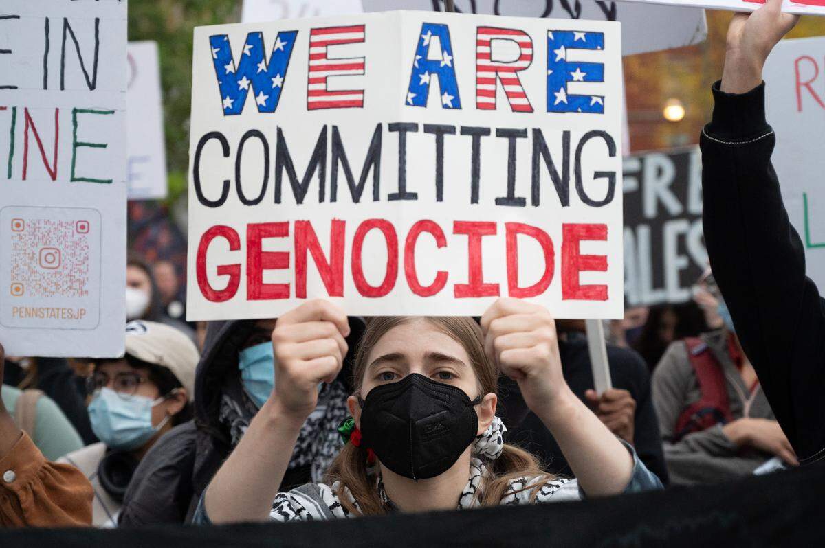 A protester holds out a sign protesting the anniversary of the Israel-Hamas War at the Allen Street Gates on Monday, Oct. 7, 2024.