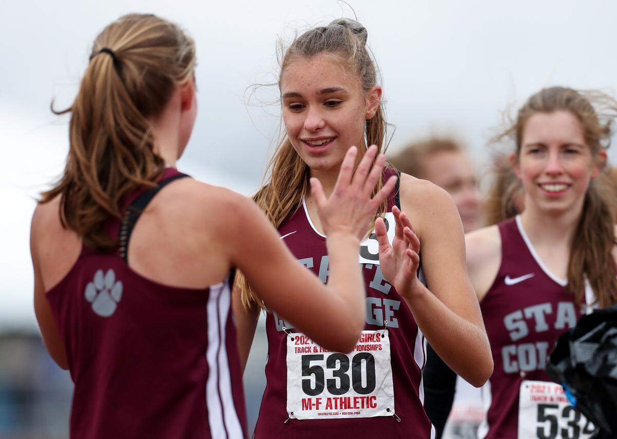 State College’s Grace Morningstar, left, is congratulated by teammate Marlee Kwasnica, right, after winning the girls Class 3A 4x800 meter relay finals during the PIAA State Track and Field Championships held Saturday, May 29, 2021, at Seth Grove Stadium on the Shippensburg University campus in Shippensburg, PA.