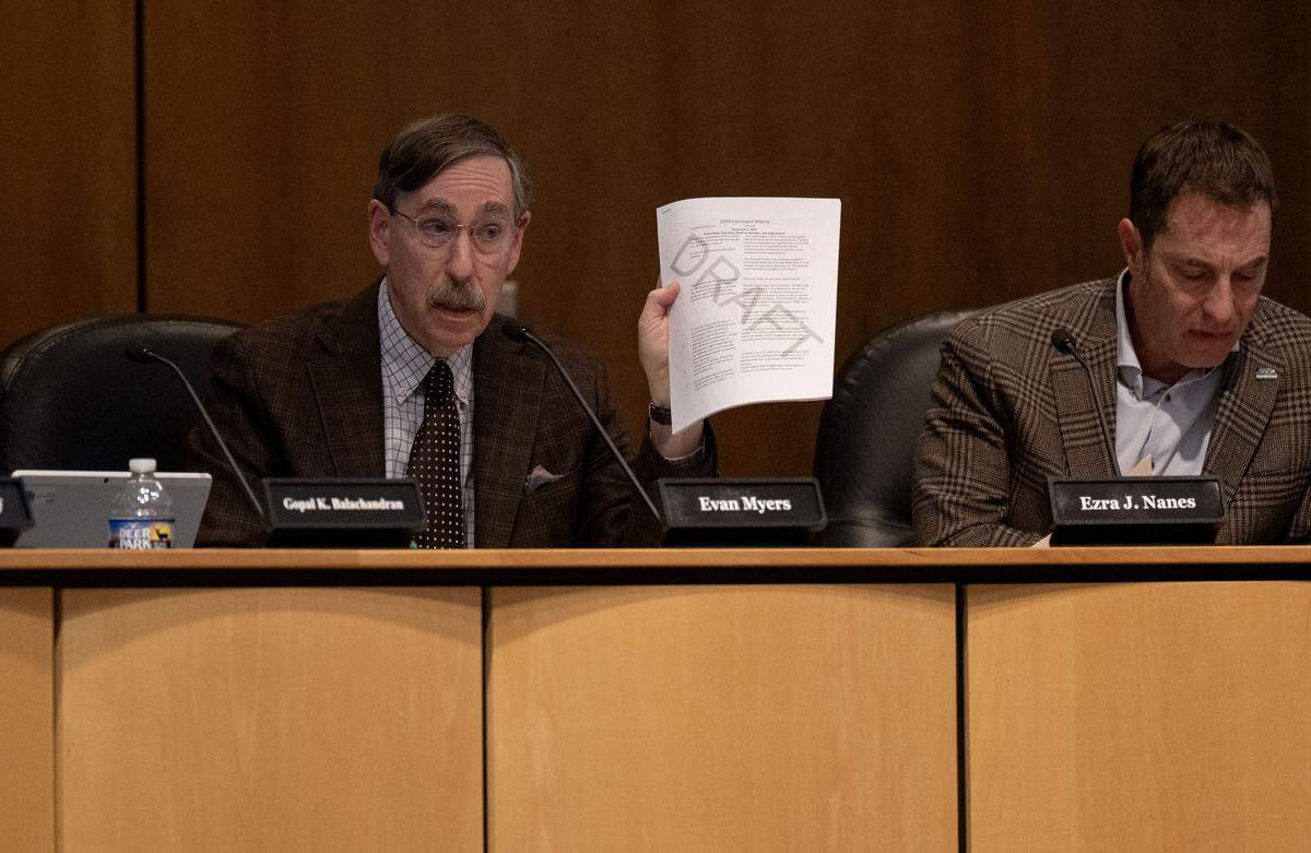 State College Borough Council President Evan Myers holds a draft document of comments about the budget during the  meeting on Monday, Dec. 1, 2025. 