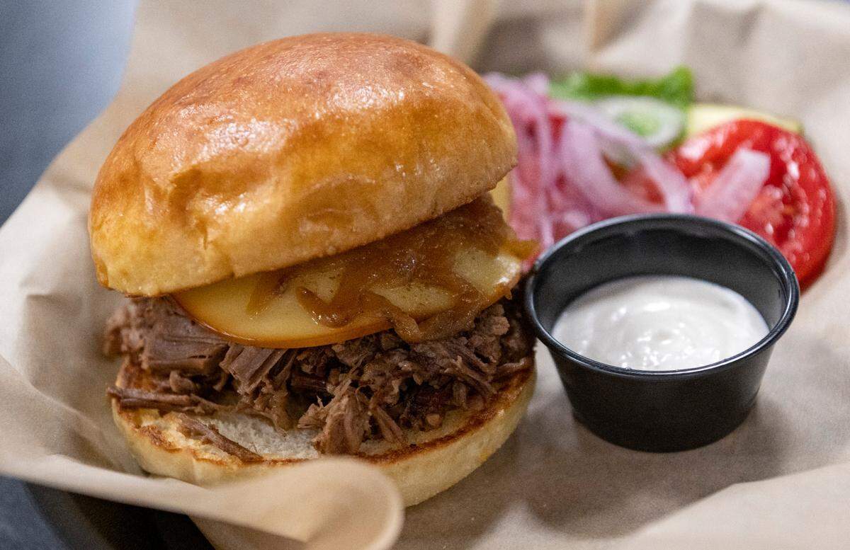 The house smoked brisket sandwich with caramelized onions, smoked Gouda cheese and horseradish sauce from The Smokey Axe Grille.