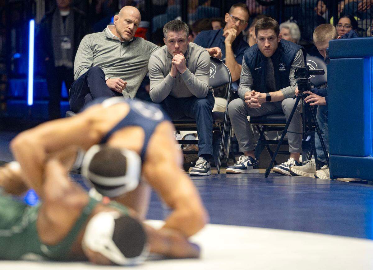 Penn State wrestling coaches Cael Sanderson, Cody Sanderson and Nick Lee watch Shayne Van Ness during his 149 lb bout of the match on Friday, Jan. 10, 2025 in Rec Hall.