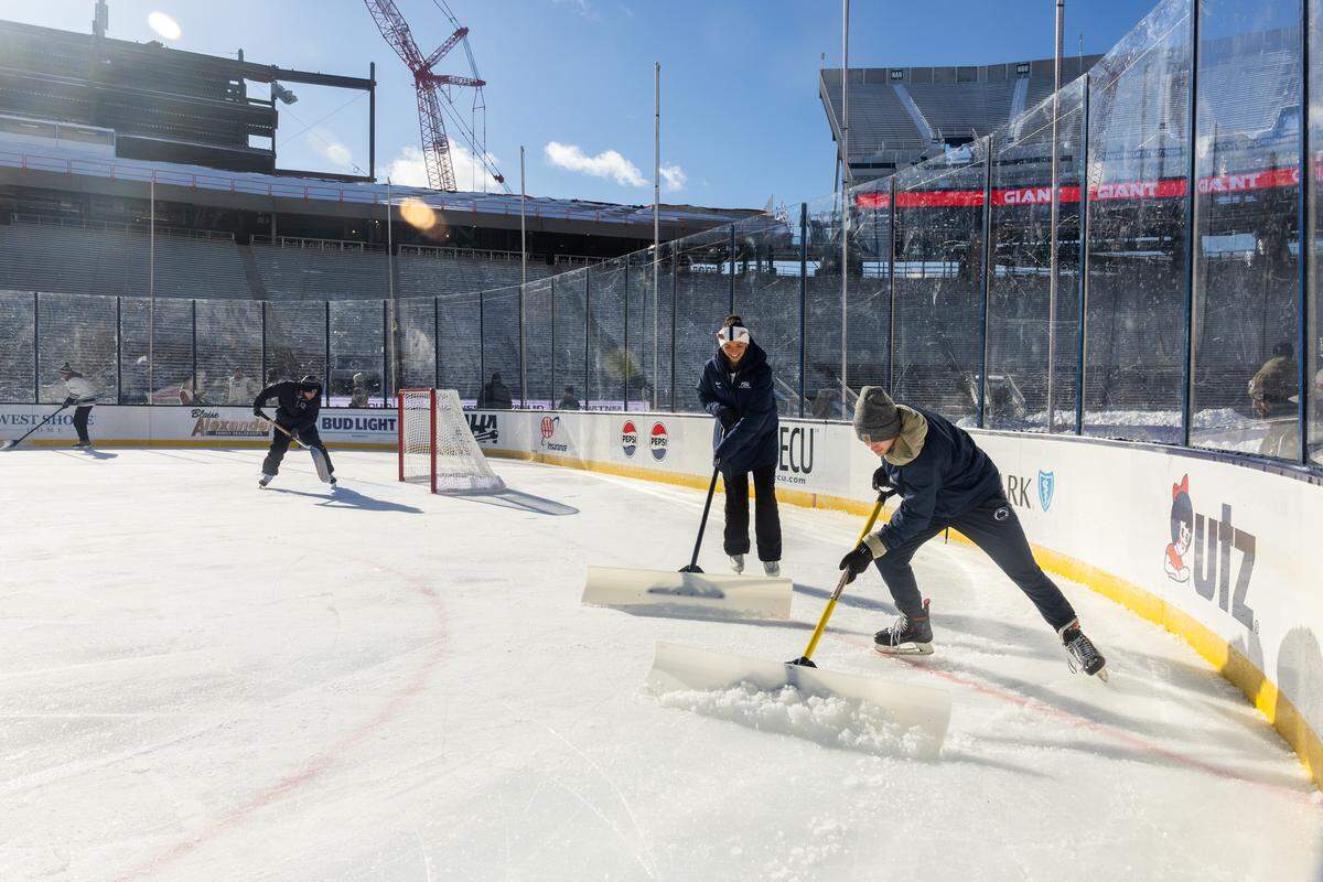 The ice maintenance crew shovels ice shavings during the Penn State women’s hockey game at Beaver Stadium on Friday, Jan. 30, 2026, in State College.