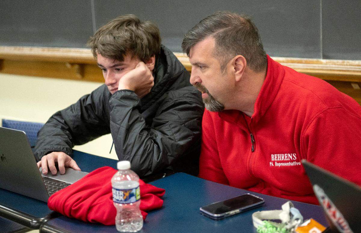 Justin Behrens watches the polling numbers come in with Penn State students who volunteered with his campaign on Tuesday, Nov. 8, 2022.