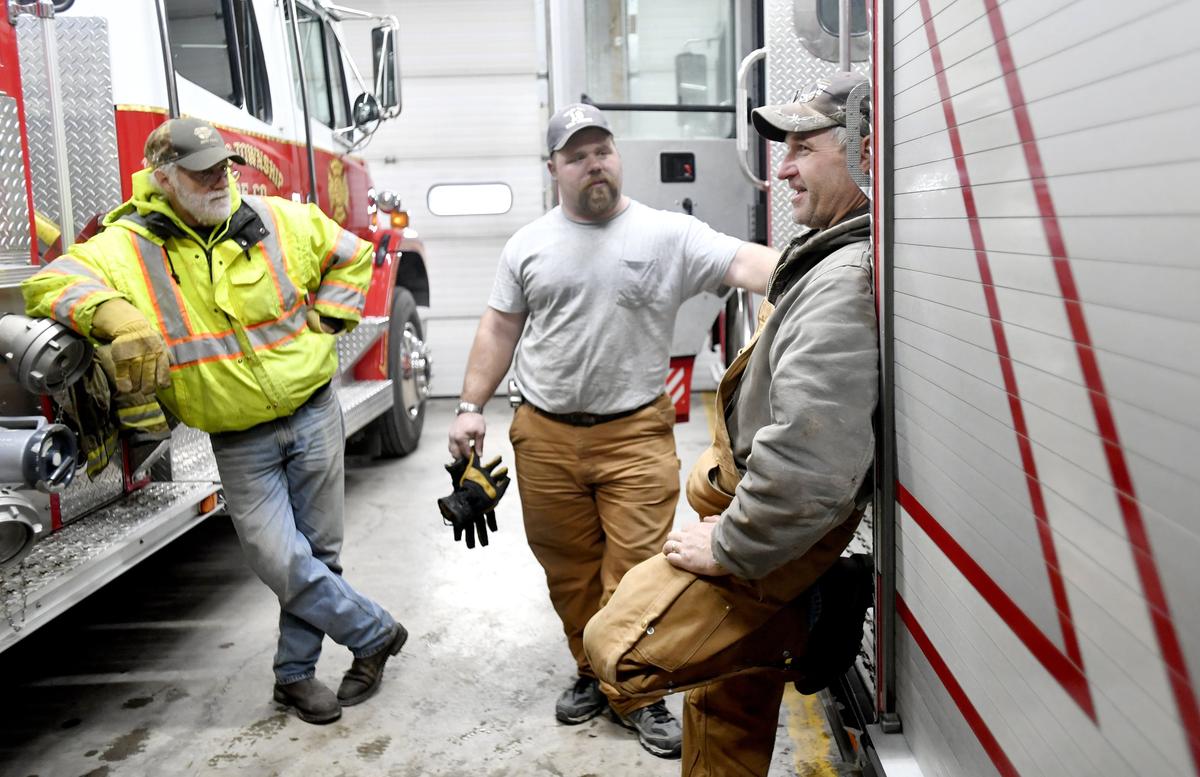 Ron Rishel Jr. leans on one of the fire trucks as he talks with fellow volunteers at the Miles Township Fire Department after they responded to a call in Haines Township on Jan. 10.