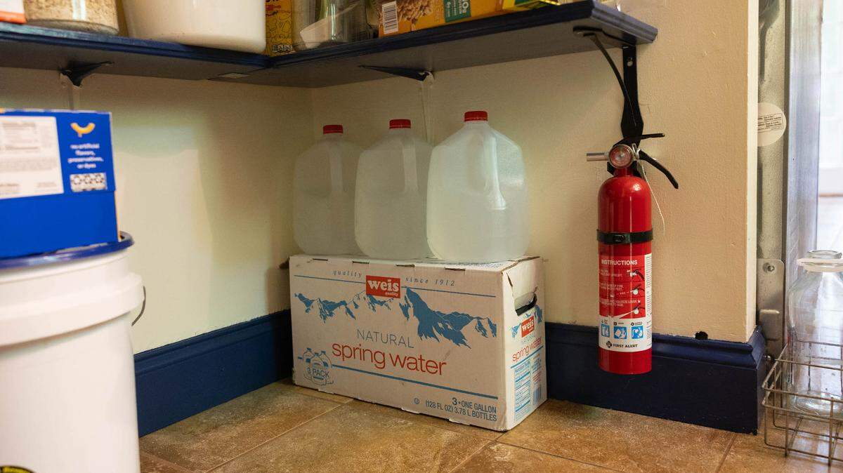 Linnet Brooks, a Rock Spring Water Company customer, keeps bottled water in her pantry due to frequent outages.