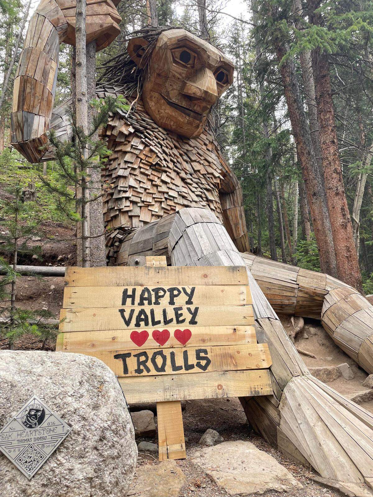 A massive Thomas Dambo troll in Breckenridge, Colo. brandishing a sign in support of a potential troll in Happy Valley.