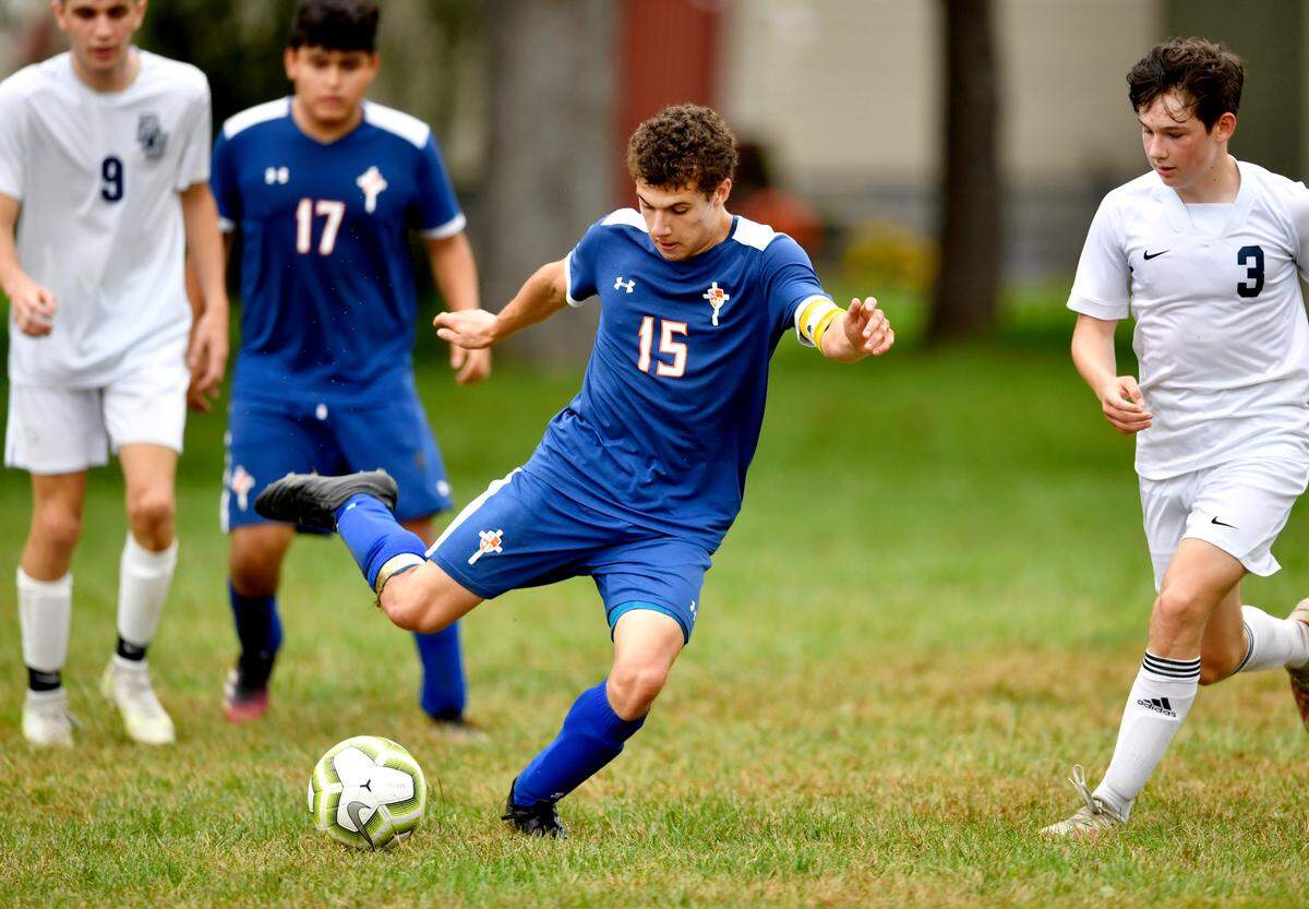 Saint Joseph’s Samuel Yangula kicks the ball ahead of Philipsburg-Osceola defenders during a game on Sept. 16, 2021.