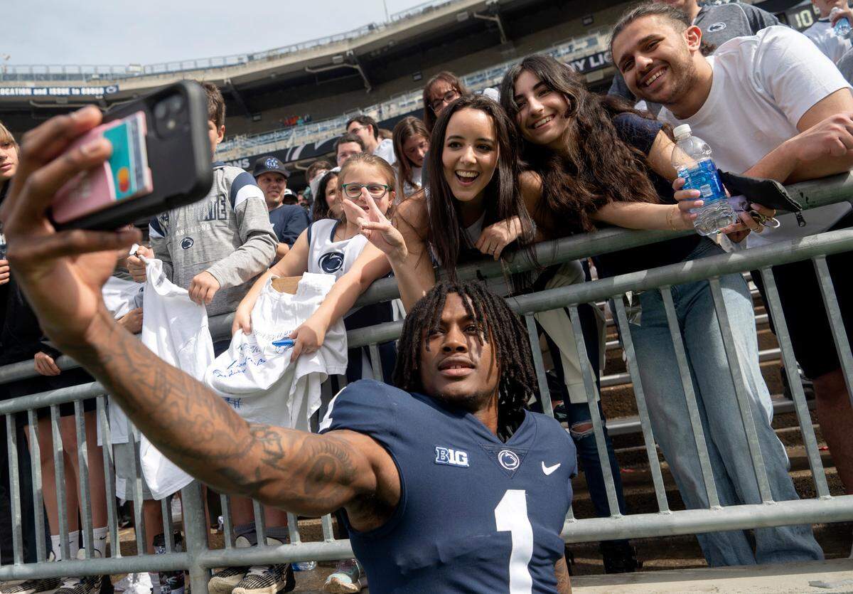 Penn State wide receiver KeAndre Lambert-Smith takes a selfie with fans after the Penn State Blue-White game on Saturday, April 15, 2023.