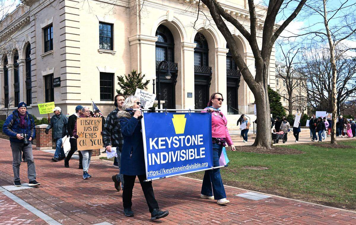 Protesters marched through the Penn State campus following a rally as part of the No Kings anti-Trump rally on Saturday.