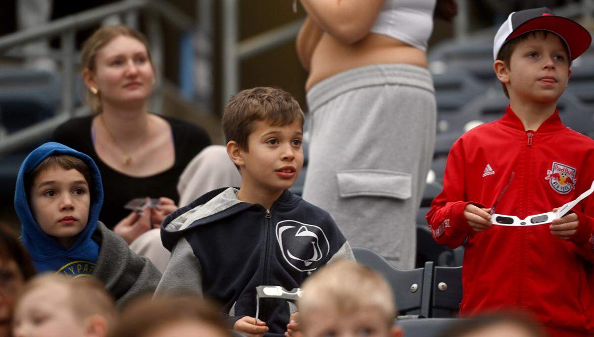 Vincent Wright, William Gorski and Brady Wertz watch the video board in excitement as it showed videos of full eclipses happening across the United States on Monday, April 8, 2024 at SolarFest.