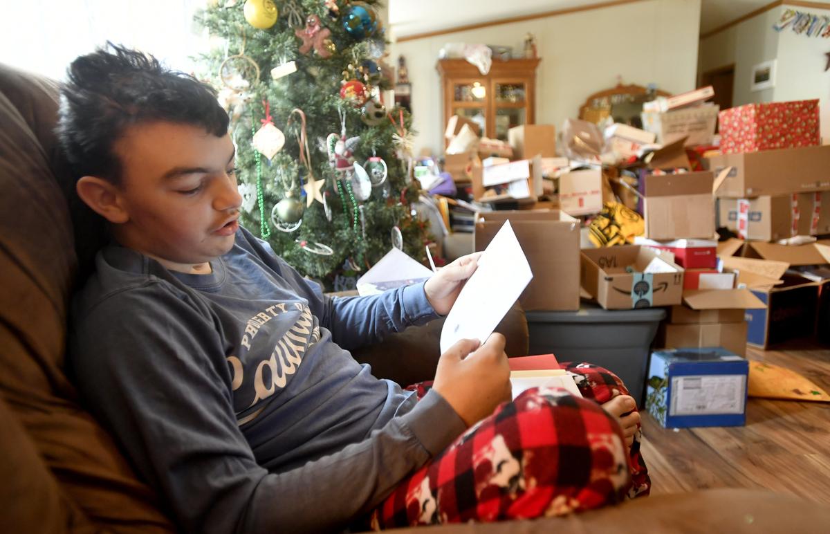 Fourteen year old Maddox Hyde reads a set of Christmas cards that were sent from a military base on Thursday, Dec. 20, 2018. Boxes of cards and packages fill his family’s Reynoldsville home after the terminally ill teen requested cards.