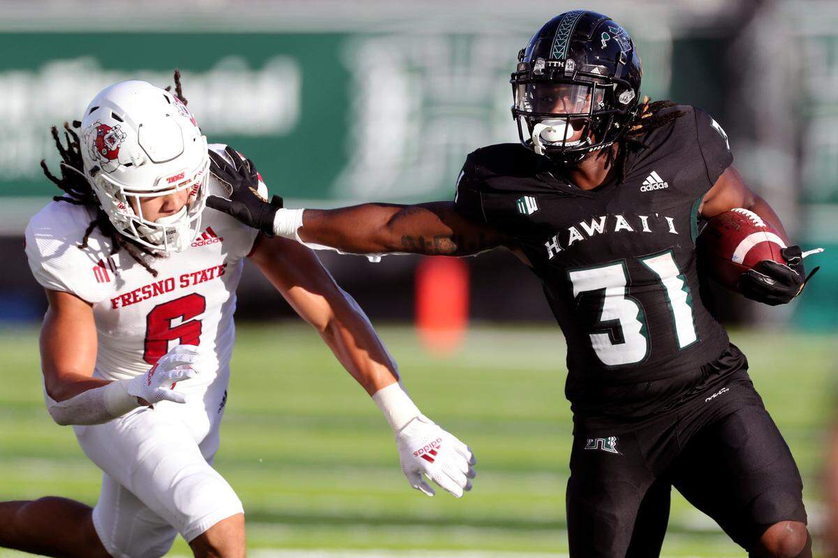 Hawaii running back Dedrick Parson (31) pushes off Fresno State linebacker Levelle Bailey (6) during the first half of a game Oct. 2, 2021, in Honolulu. Parson is from Philadelphia.