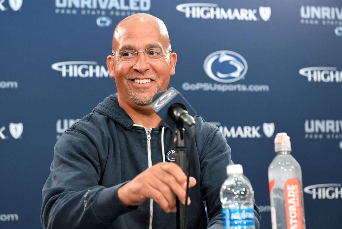 Penn State football coach James Franklin adjusts the microphone as he sits down for his weekly press conference before the season opener on Monday, Aug. 26, 2024.