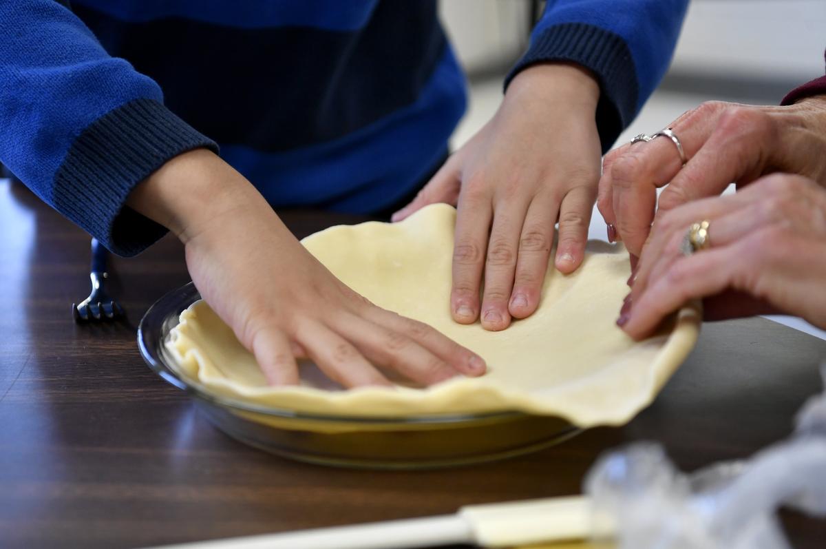 Third grader David Zhang works with Mount Nittany Elementary ESL teacher Lori Maxfield to make pumpkin pies on Nov. 21 at Mount Nittany Middle School.