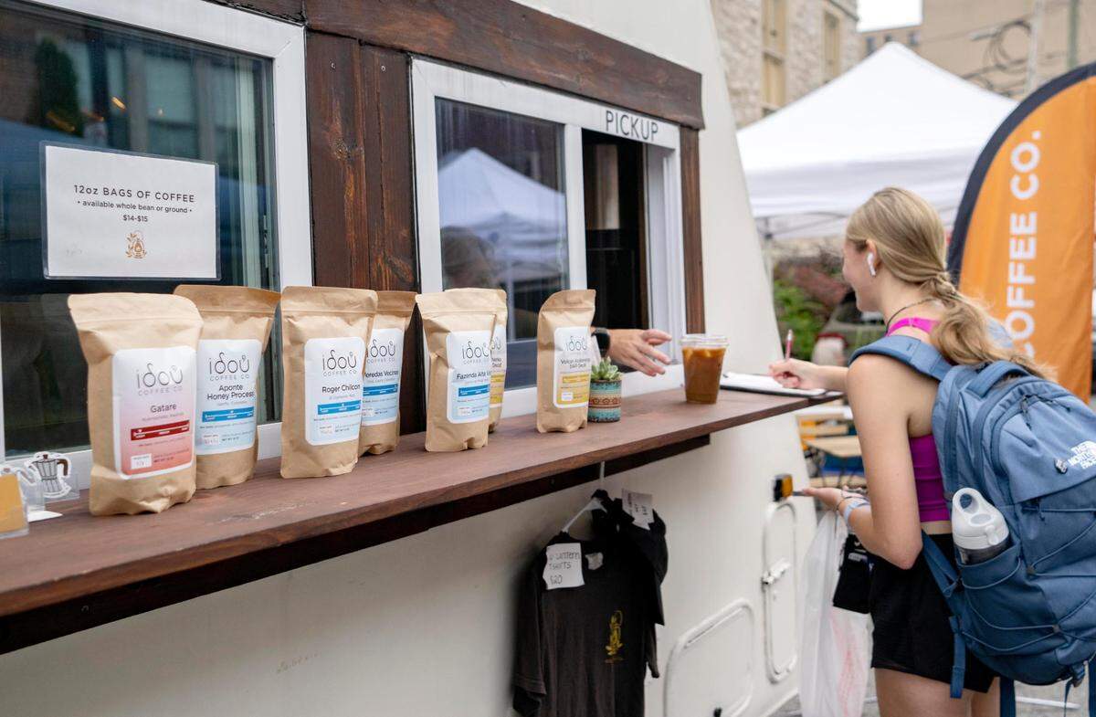 A customer gets a drink from the Idou Coffee Co. trailer at the Downtown Farmers Market on Friday, July 29, 2022.