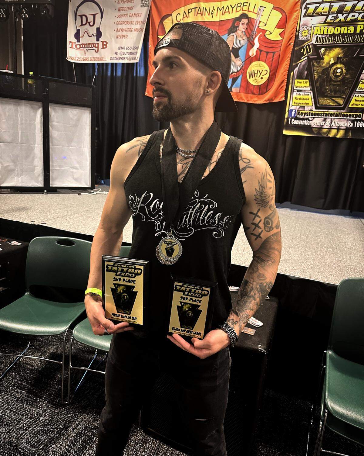 Tyler Walstrom holds a pair of awards his shop won during the recent Keystone State Tattoo Expo Convention in Altoona.