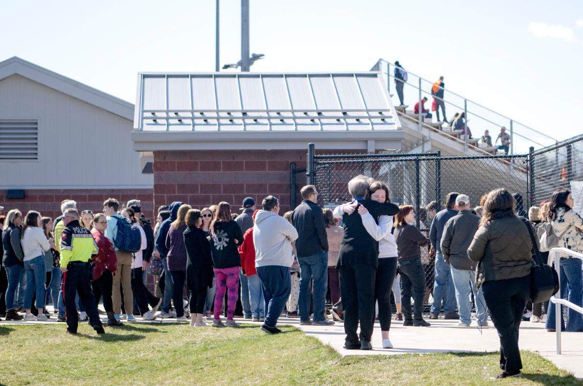 Parents and students hug as they unite outside of the football stadium after the Bellefonte Area High School received a threat on Wednesday, March 29, 2023. The threat was determined not credible and students were released to guardians.