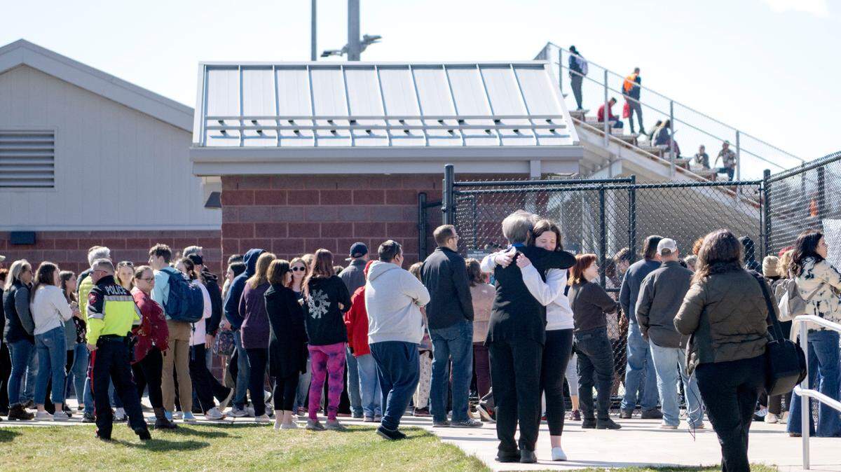 Parents and students hug as they unite outside of the football stadium after the Bellefonte Area High School received a threat on Wednesday. The threat was determined not credible and students were released to guardians.