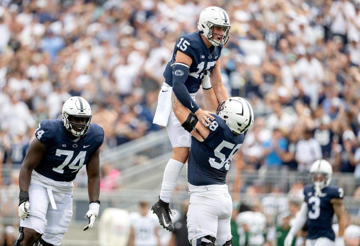 Penn State offensive lineman Landon Tengwall lifts up quarterback Drew Allar after he threw his first touchdown pass in Beaver Stadium during the game against Ohio on Saturday, Sept. 10, 2022.