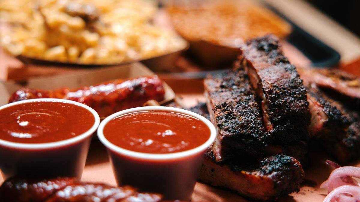 Large servings of barbecue, with pork ribs, sausage, macaroni and cheese, and baked beans. Shot in Houston, Texas, USA.