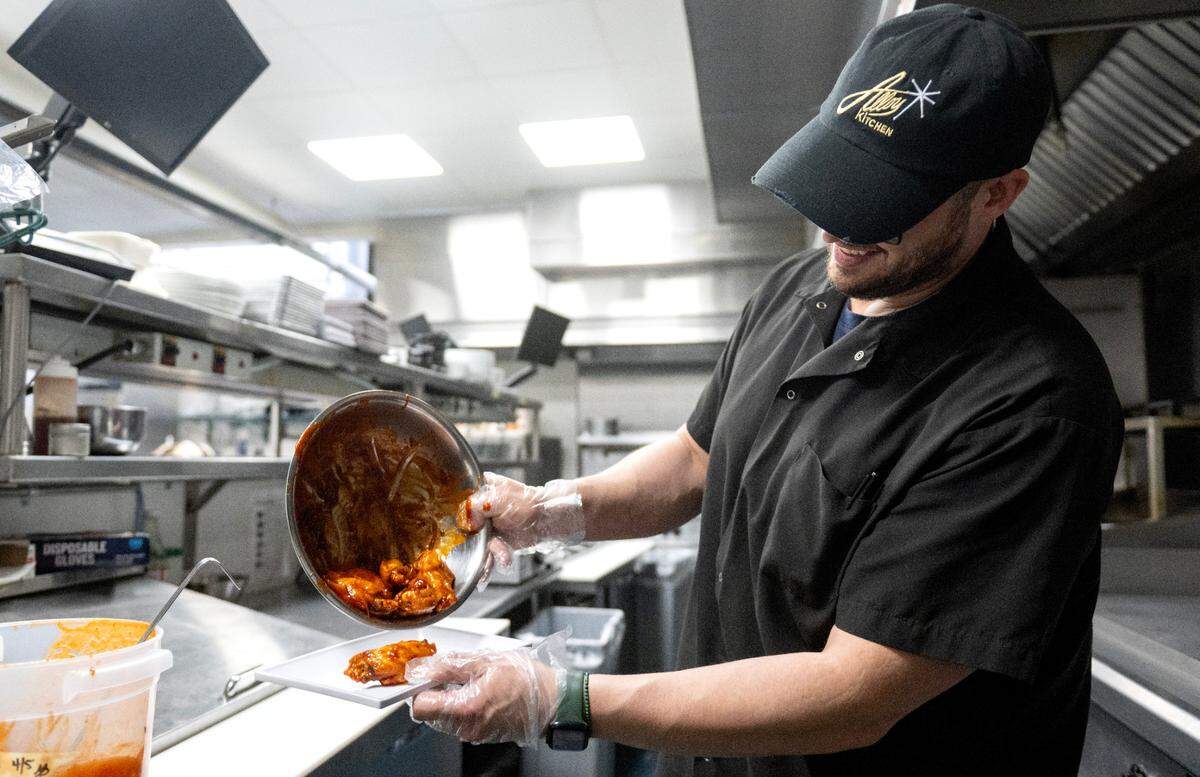Tony Caracillo, the new owner of Alloy Kitchen, preps an order of Nelly’s Jumbo Sweet and Spicy wings on Thursday, April 10, 2025.