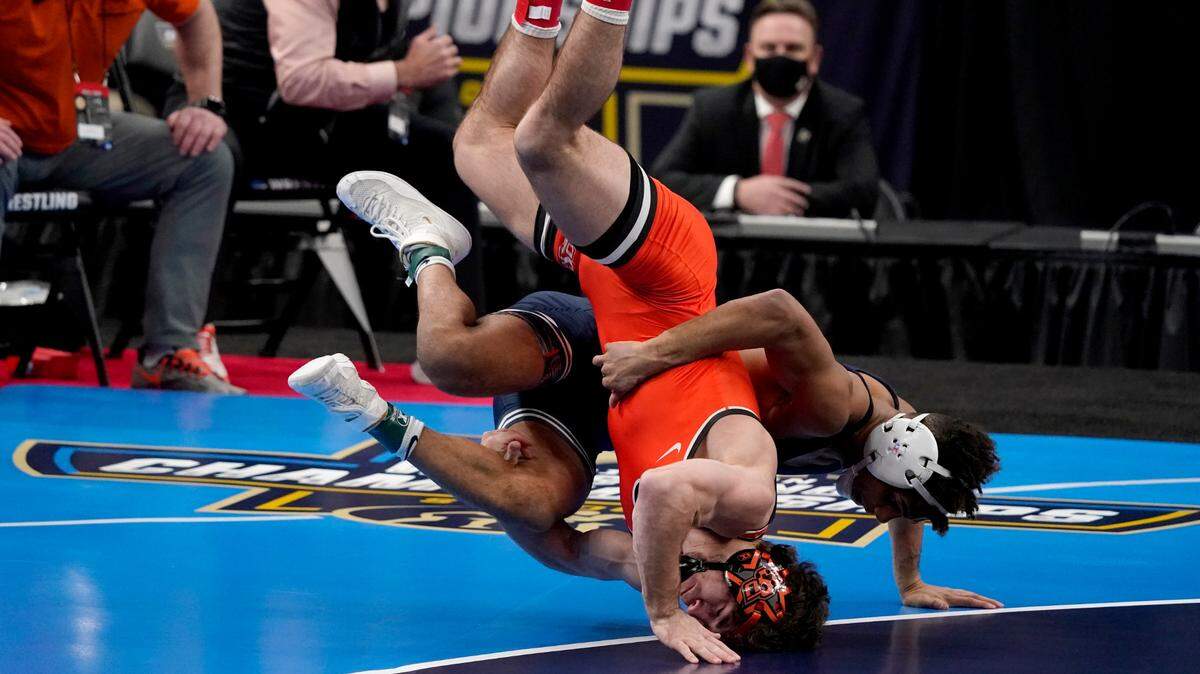 Oklahoma State’s Daton Fix, front, takes on Penn State’s Roman Bravo-Young during their 133-pound match in the finals of the NCAA wrestling championships Saturday, March 20, 2021, in St. Louis. (AP Photo/Jeff Roberson)