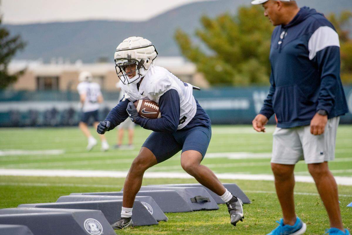 Penn State’s Nick Singleton runs a drill while running backs coach Ja’Juan Seider watches during practice on Wednesday, Oct. 12, 2022.