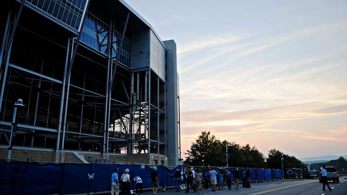 The sun sets over Beaver Stadium as visitors stop by the site where the Joe Paterno's statue was on Sunday, July 22, 2012.  Abby Drey / CENTRE DAILY TIMES
