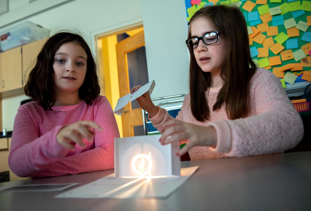Sophie Blanford, left, and Daisy Baumer, right, do the light experiment together in the STEM class on Oct. 17, 2018, at Ferguson Township Elementary School in State College, Pa. (Photo/Baidi Wang)