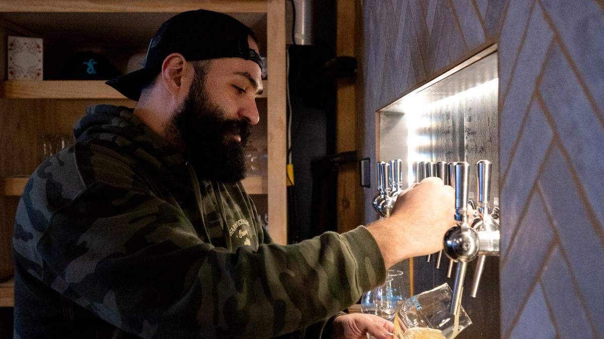 Paulo Nami, head brewer at Antifragile Brewing Company, taps an Optionality #22 for a taste test on Tuesday, Nov. 28, 2023.