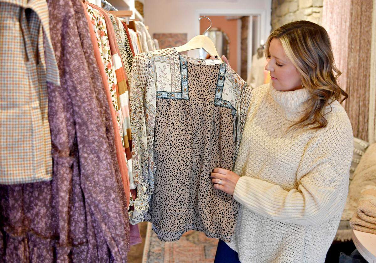 Emily Boon shows a blouse at By A Thread, a women’s clothing boutique on High Street in Bellefonte.