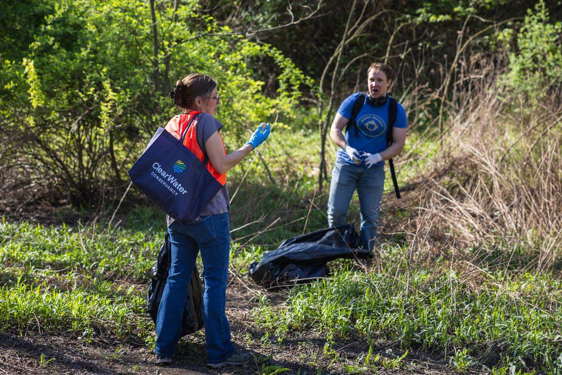 Volunteers AJ Legmier, left, and Trevor White, right, examine a piece of trash they collected in Pine Grove Mills, Pa., on Saturday, April 18, 2026. The ClearWater Conservancy organized volunteers across Centre County to clean up public green spaces.