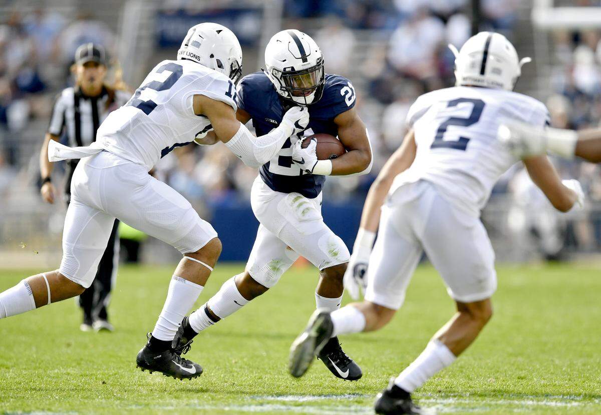 Penn State running back Noah Cain cuts down the field with the ball from linebacker Brandon Smith during the Blue-White game on Saturday, April 13, 2019.