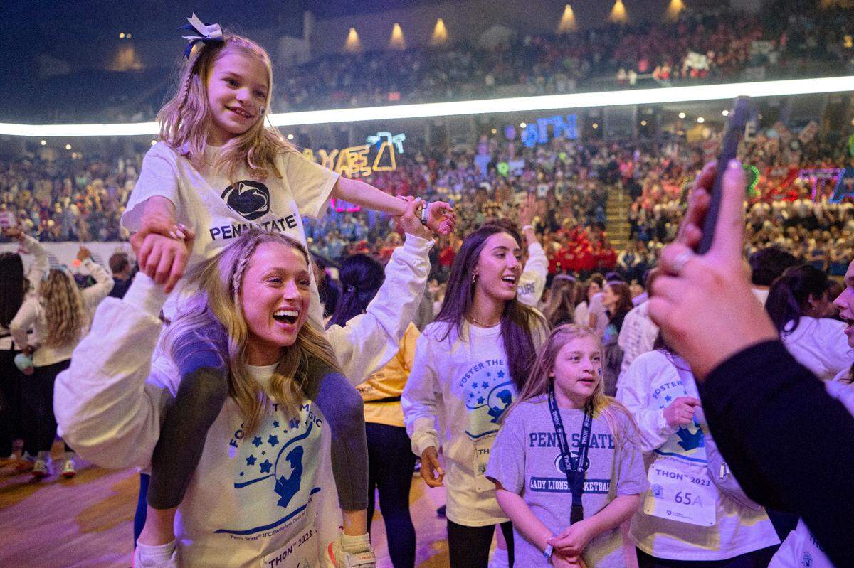 Shiloh Crimmel, 6, dances on the shoulders of Molly Saltzman as the Penn State IFC/Panhellenic Dance Marathon kicks off on Friday, Feb. 17, 2023 at the Bryce Jordan Center.