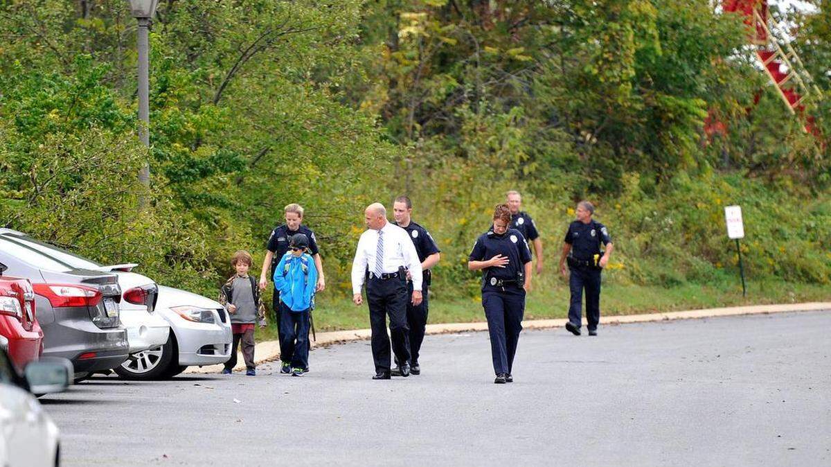 Police officers walk with two boys on Ashworth Lane in Boalsburg after they were reported missing earlier in the day, Tuesday, Sept. 22, 2015. 
