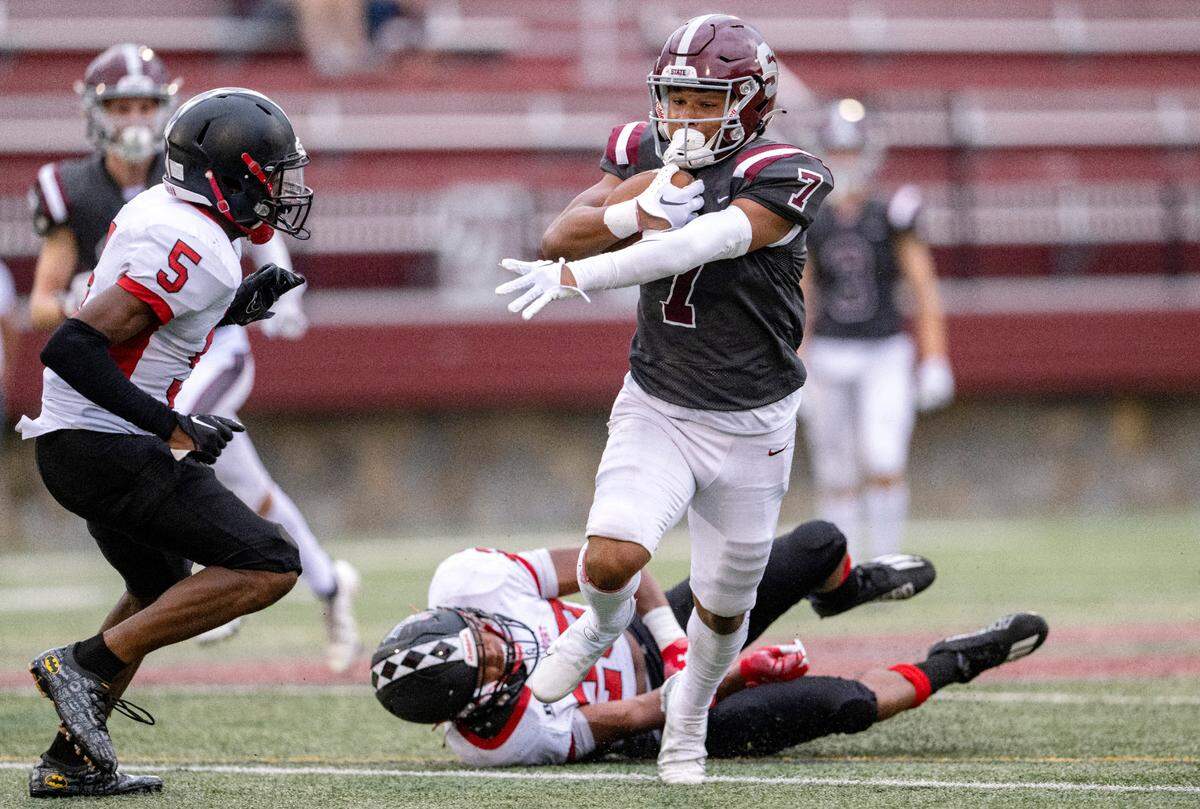 State College’s D’antae Sheffey cuts down the field with the ball from Williamsport defenders during the game on Friday, Aug. 26, 2022 at Memorial Field.