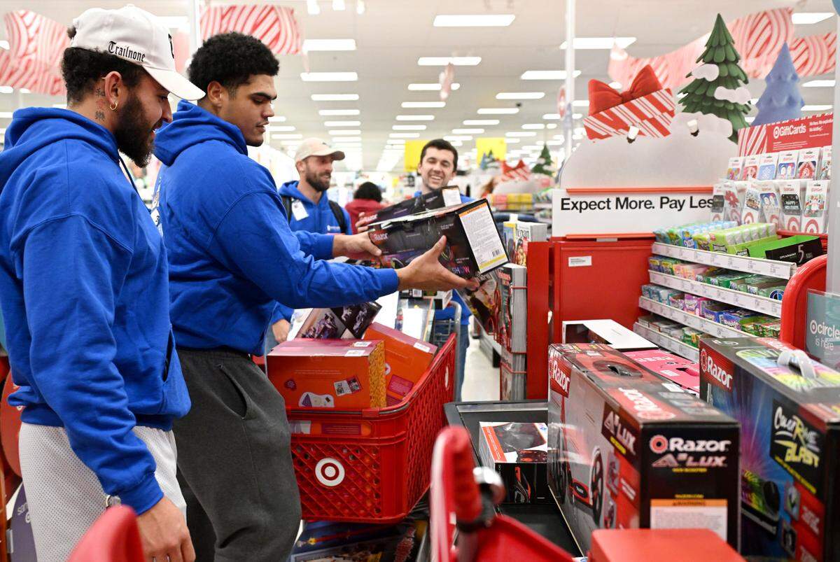 Penn State football players Julian Fleming and Drew Shelton unload toys at the register as they help West Shore Home shop for Toys for Tots on Monday, Dec. 2, 2024 at Target.