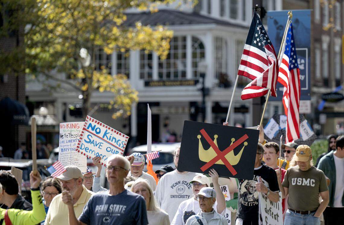 Protesters marched on the sidewalks along College Avenue  as part of the No Kings anti-Trump rally on Saturday, Oct. 18, 2025. 