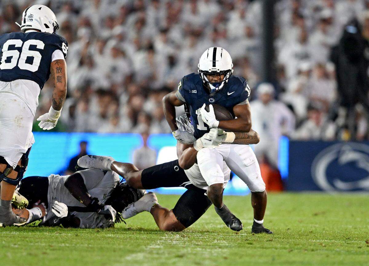 Oregon defenders try to pull down Penn State running back Nick Singleton during the game on Saturday, Sept. 27, 2025.  