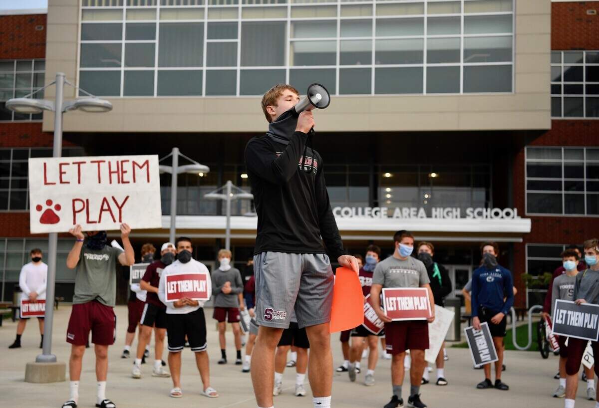 State College quarterback Conrad Moore speaks during the Save Our Sports rally on Wednesday outside the high school.