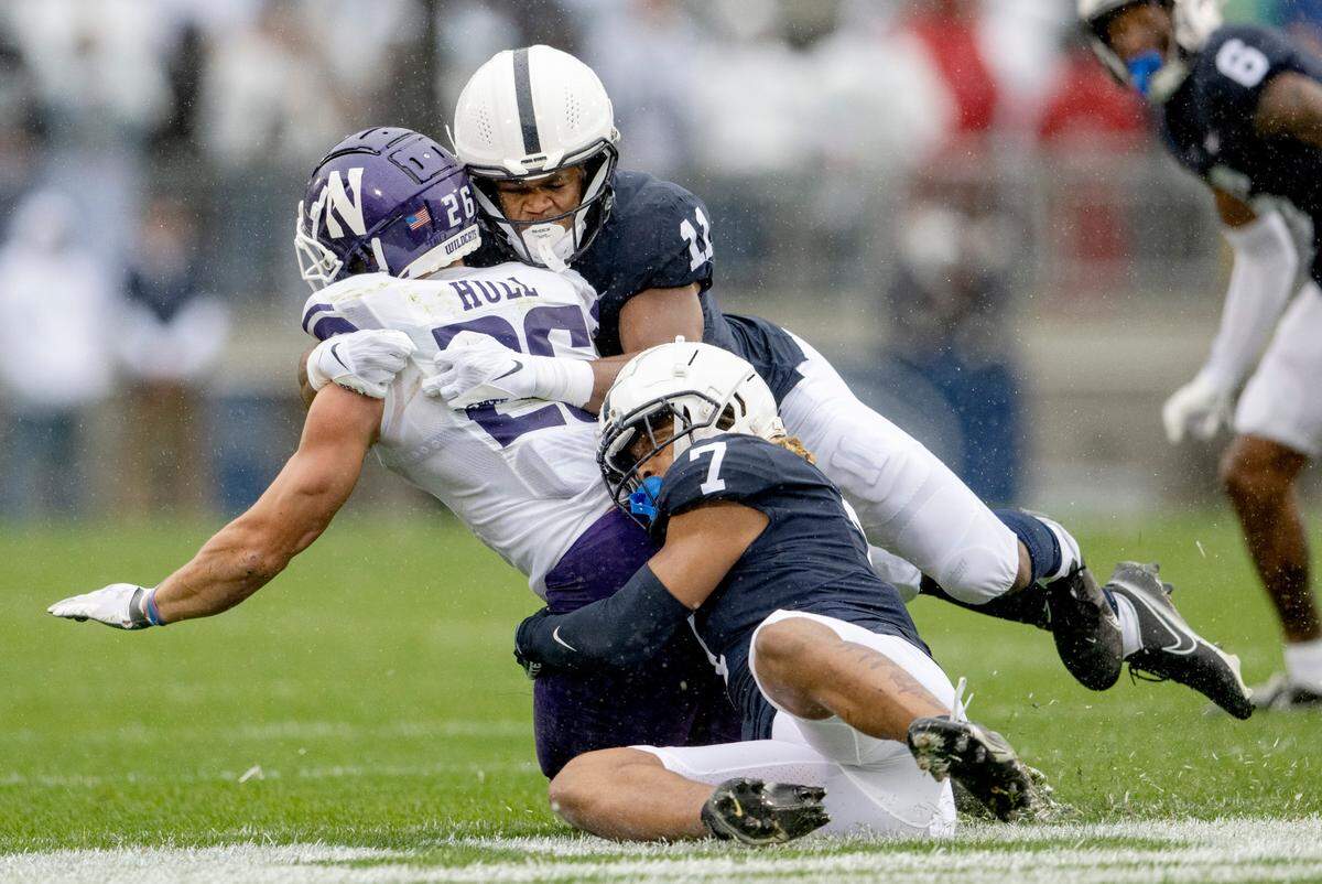 Penn State linebacker Abdul Carter and Penn State safety Jaylen Reed stop Northwestern’s ball carrier Evan Hull during the game on Saturday, Oct. 1, 2022.