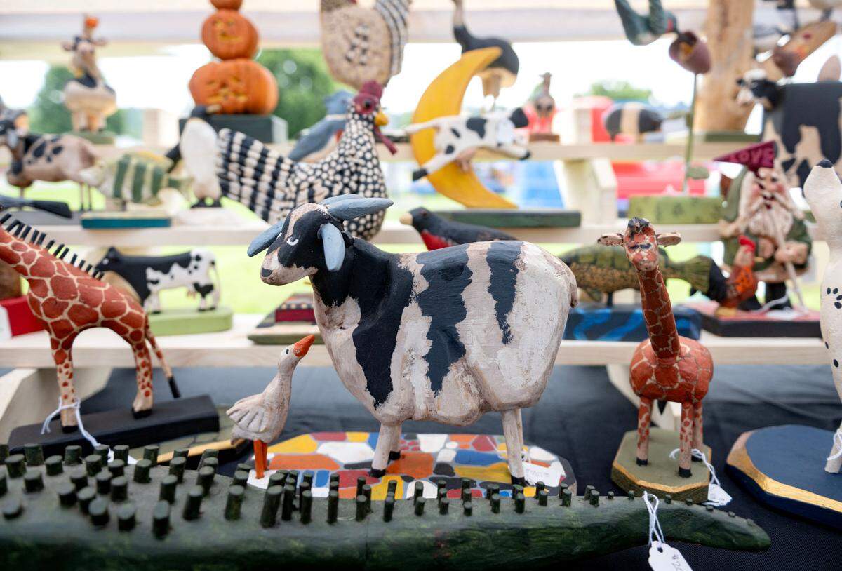 A cow among the pine wood carved animals by Jim Richtscheit at the People’s Choice Festival of Pennsylvania on Thursday, July 10, 2025.