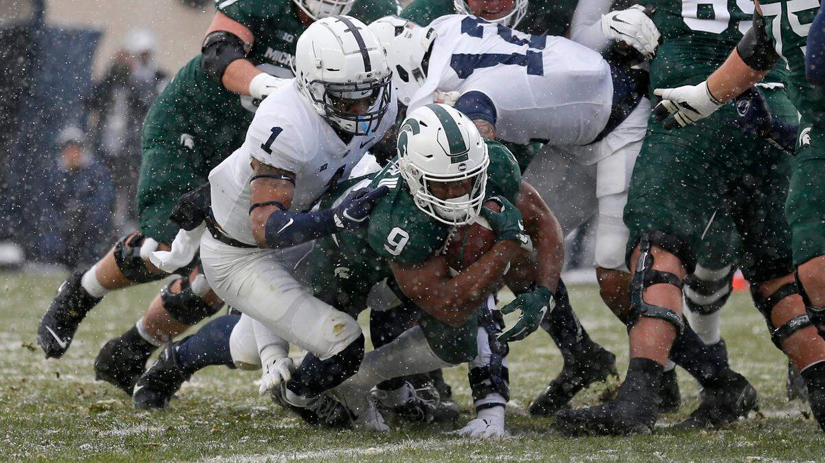 Michigan State’s Kenneth Walker III (9) rushes for a touchdown against Penn State’s Jaquan Brisker (1) during the first quarter of an NCAA college football game, Saturday, Nov. 27, 2021, in East Lansing, Mich. (AP Photo/Al Goldis)