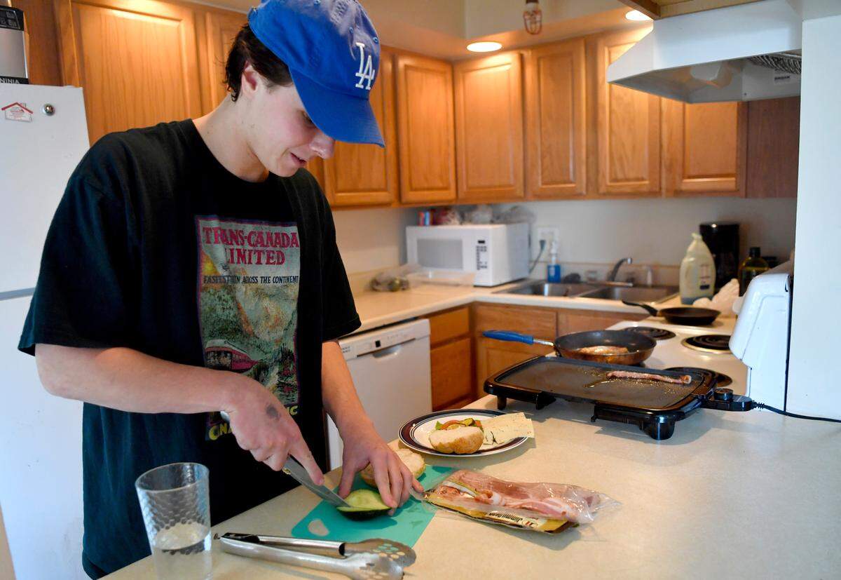 Penn State student Nick Cradler makes a grilled chicken sandwich at his downtown apartment on Wednesday, Feb. 24, 2021.