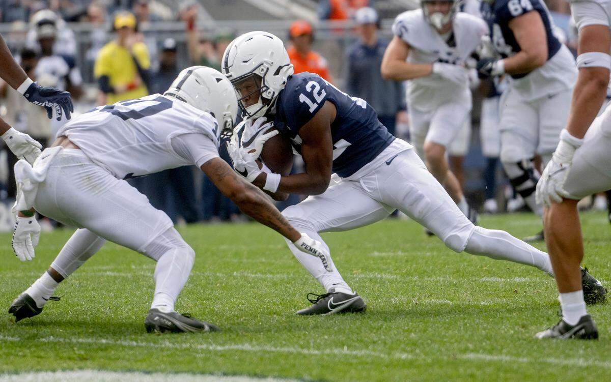 Penn State wide receiver Anthony Ivey cuts down the field with the ball as safety Mehki Flowers reaches for the tackle during the Penn State Blue-White game on Saturday, April 15, 2023.