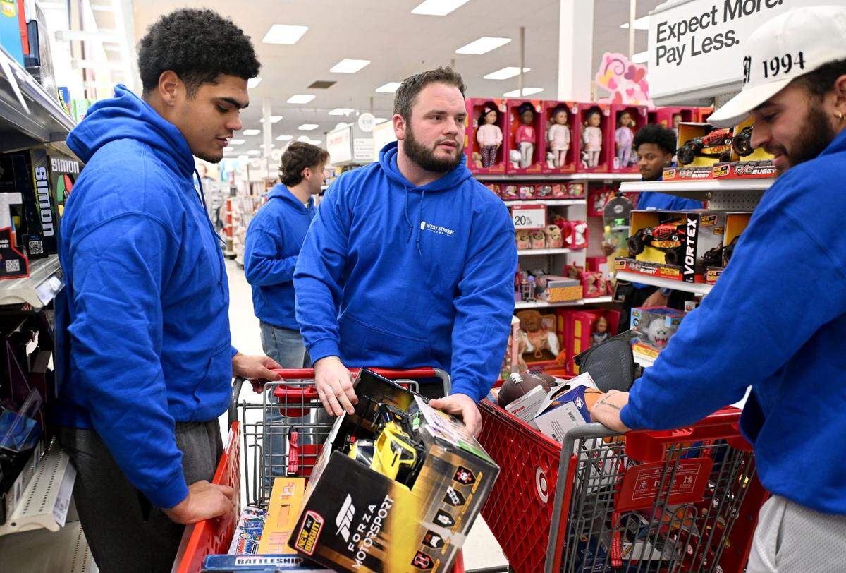 Penn State football players Drew Shelton, Dominic Rulli and Julian Fleming compare toys as they help West Shore Home shop for Toys for Tots on Monday, Dec. 2, 2024 at Target.