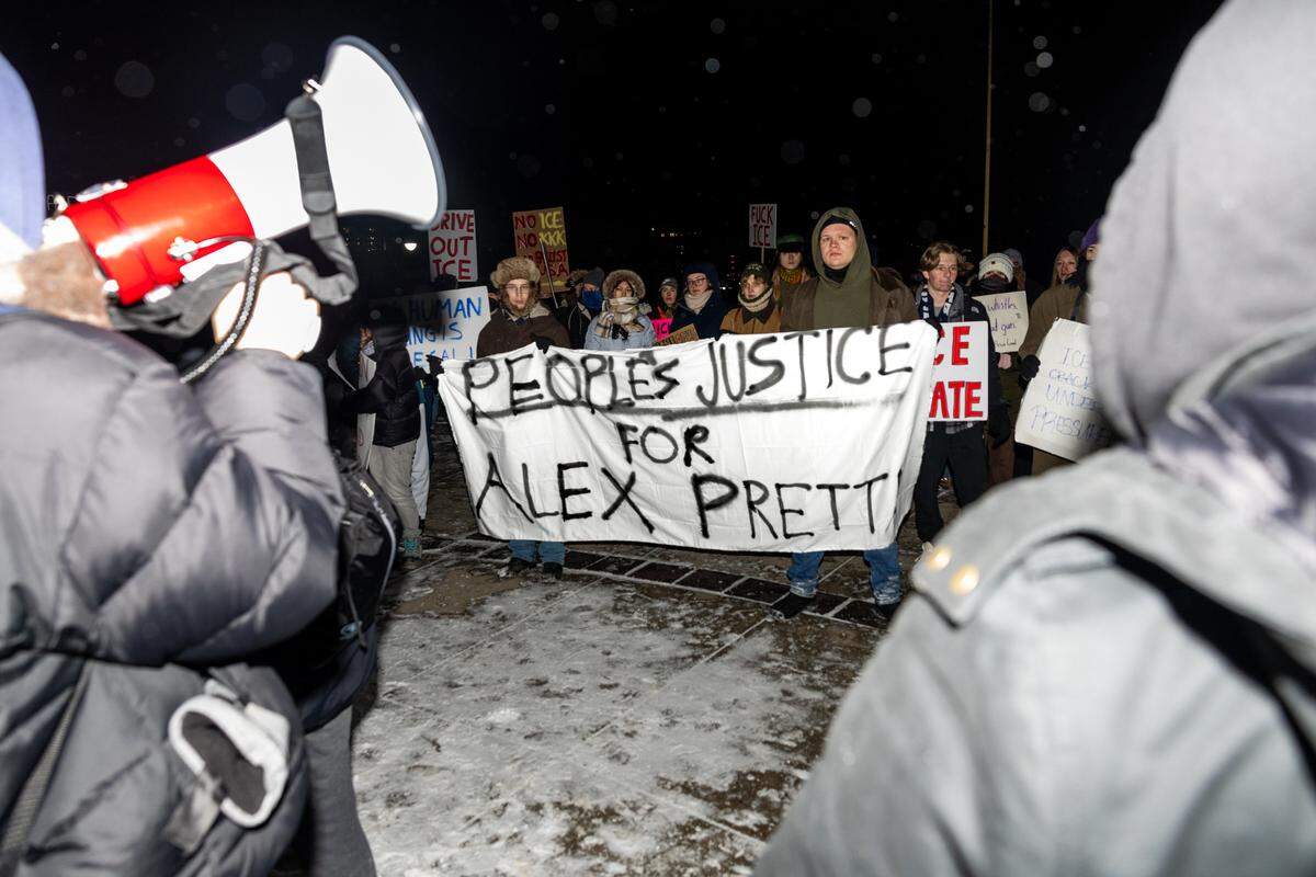 A banner reading “Peoples Justice for Alex Pretti” is held in front of the steps of Old Main during the conclusion of a protest on Monday.